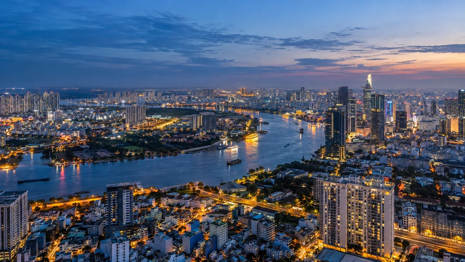 TP.HCM nhìn từ trên cao lúc chập tối, sông Sài Gòn uốn quanh các quận với đèn sáng khắp nơi